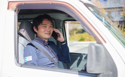 配送車を停め、車内で電話をかけている様子