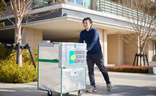 配送用の保冷カバー付き台車で荷物を運んでいる様子